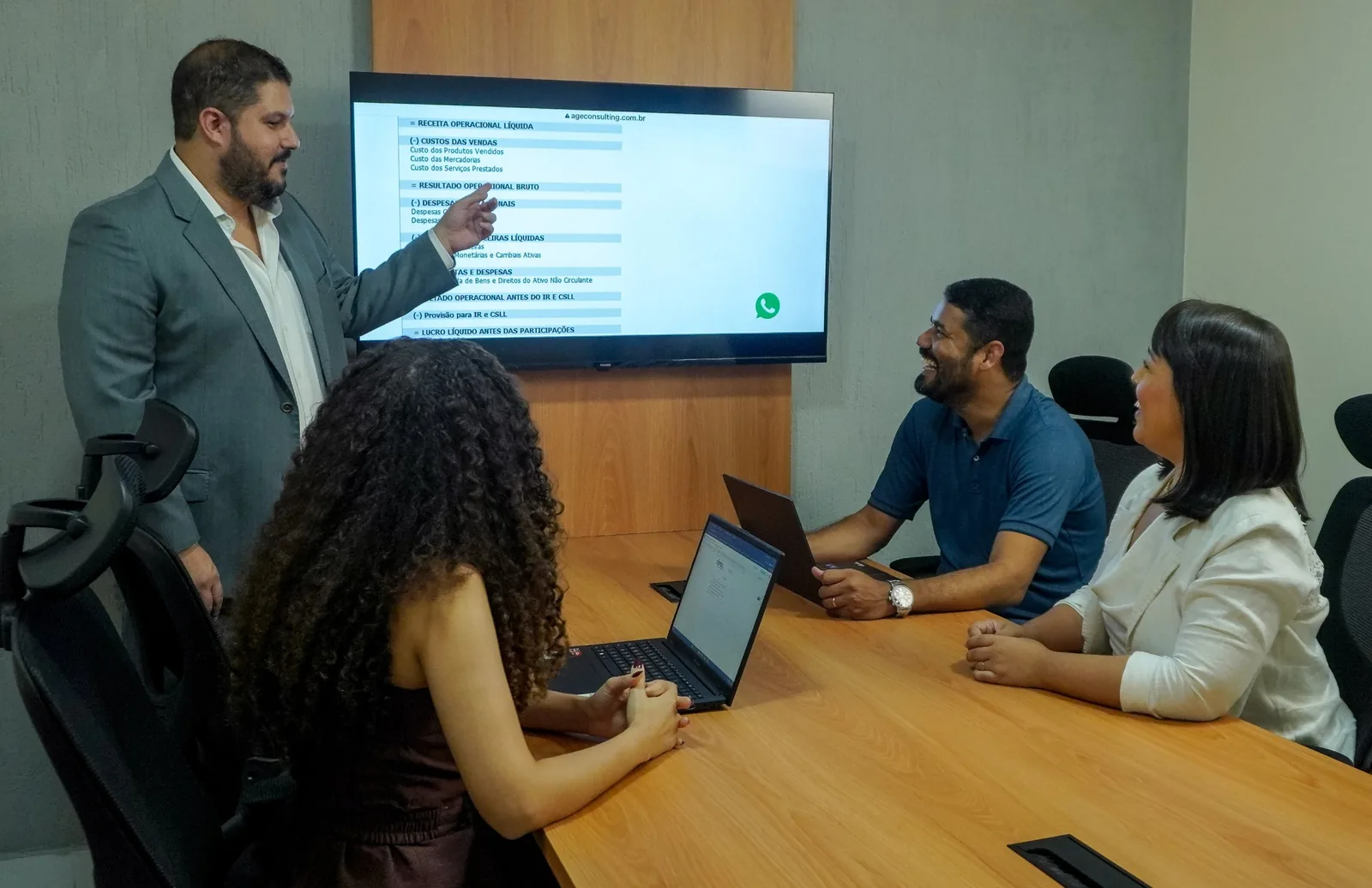Reunião de trabalho com análise de demonstrativo financeiro na tela